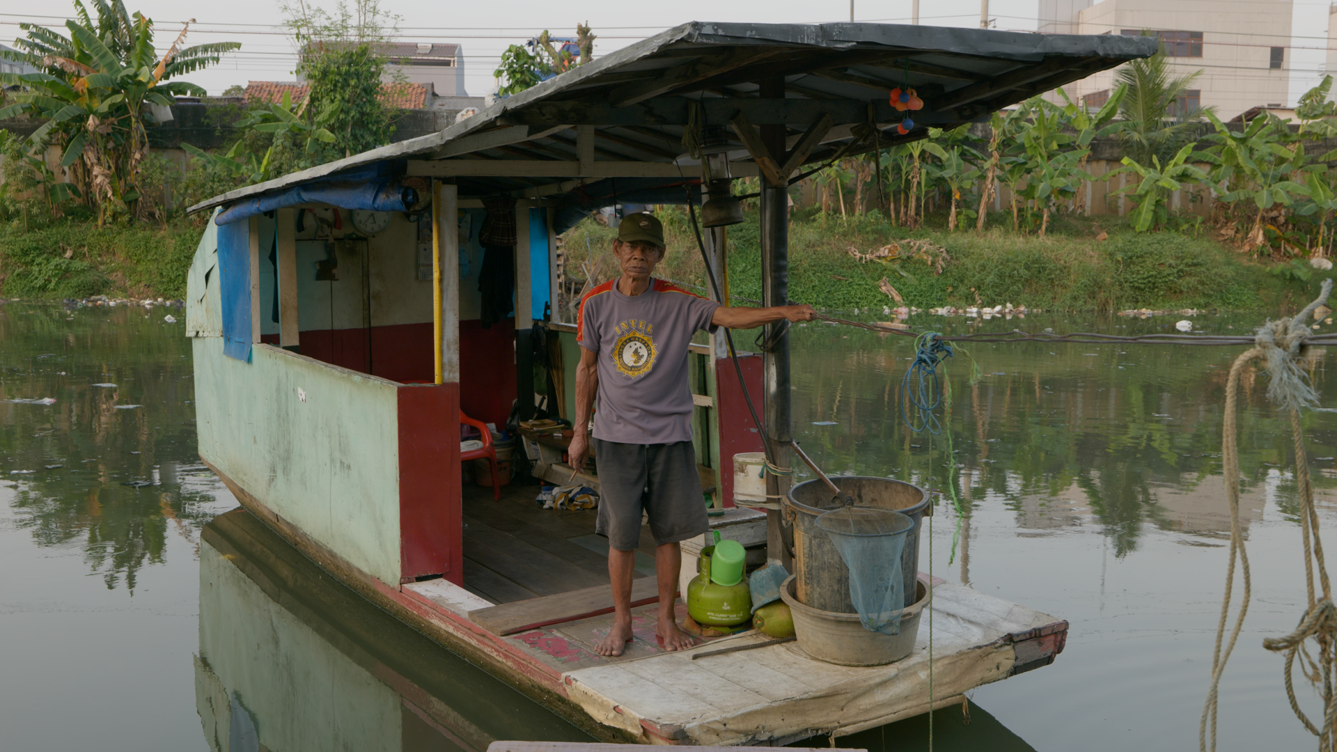 Film still from 'The Old Land'. Panana on a boat on the river.