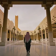 A Saudi Arabian man wearing a keffiyeh walks down a large open courtyard of the Prince Mohammed Bin Nayef Centre for Counselling and Care. From Meg Smaker’s ‘Jihad Rehab.’ Courtesy of Sidestilt Films.