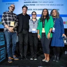 Participants in a panel at DOC NYC about the ADE Guidelines and the BIPOC Editors Database pose in front of a screen with text on it. Courtesy of DOC NYC.